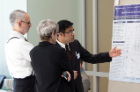 Sumeet Munjal, MD (far right), discusses his research with Alan J. Lesse, MD, and Susan Graham, MD.