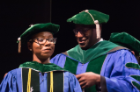 Janelle Duah is hooded by her uncle, Eric Duah, MD, before receiving her diploma.
