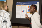 Medicine-pediatrics resident Claudia Clarke, DO, right, discusses her research with Anne B. Curtis, MD, chair of medicine.