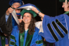 Gwenn Santoro (center), who will pursue a pediatrics residency at UB, is hooded by Andrea T. Manyon, MD (right), and Frank T. Schimpfhauser, PhD.