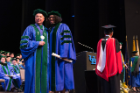 Shanté White poses for a photograph with Michael E. Cain, MD, after recieving her medical degree.