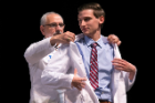 Class of 2022 student Brandon Ewing, right, receives his white coat from Alan J. Lesse, MD.