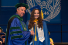 Michael E. Cain, MD, vice president for health sciences and dean of the Jacobs School, congratulates Lindsey J. Carlsen, who earned a bachelor’s degree in biotechnology and an outstanding senior award in her field. 