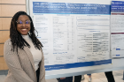 Second-year medical student Sydney Johnson stands by her research poster about the evaluation of patient-centered education animations about kidney transplant complications.