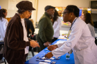 Nonye Odukwe, a first-year medical student, gives Eloise Hunter an enthusiastic welcome to the health fair.