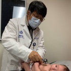 Photo of a doctor examining a baby. 