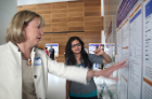 Anne B. Curtis, MD (left), discusses a poster with medical resident Deepika Narasimha, MD.