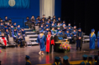 A graduate is greeted by UB President Satish K. Tripathi as she receives her diploma on the Center for the Arts stage.