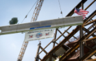The steel beam, one of 7,459 beams for the new downtown medical school building, was hoisted atop the eight-story structure and put into place at Washington and High streets.
