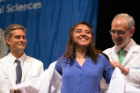 Incoming medical student Angelica Suarez-Ramirez is coated by Alan J. Lesse, MD, senior associate dean for medical curriculum. Daniel W. Sheehan, MD, PhD, associate dean for medical curriculum, is at left.
