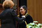 Kristine Peregrino Lacuna receives her Latin honors cords from Andrea T. Manyon, MD, associate dean for student affairs.
