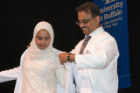 Sana Saeed, left, dons her new white coat with the help of Imtiaz A. Patel, MD, her uncle.