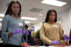 UB undergraduate students Bianca S. St. Cilien, left, and Kwesiann C. Regent practice their suturing techniques on pigs’ feet during one of the Rx for Success program’s workshops.