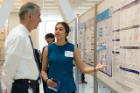 Timothy F. Murphy, MD, senior associate dean for clinical and translational research, listens to Jenna Betz present her research on preventing the development of the human autoimmune disease pemphigus vulgaris.