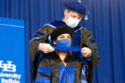 Poonam Choudhary is hooded by Ferdinand Schwezer, PhD, assistant professor of neurology and biomedical engineering, after earning her doctoral degree in medical physics.