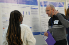 Research forum judge Husam A. Ghanim, PhD, a faculty member in the Department of Medicine, talks to a medical student about her poster presentation.