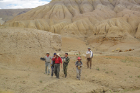 Juan Liu, PhD, (wearing red hat) and her colleagues retrieve fossils from a deep gulley and take them back to their camp on the Tibetan Plateau.