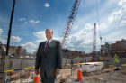 Vice President and Dean Michael E. Cain in front of the construction site of UB’s future medical school in downtown Buffalo, set to open in 2017.