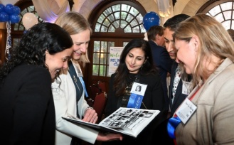 Group of alumni reviewing a year book. 