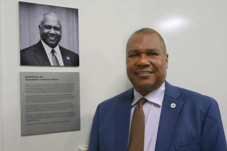 David Kountz, MD '85 standing in front of his classroom's plaque. 