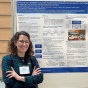 Elizabeth Kubiniec stands by her poster on UB Research Day 2025. 