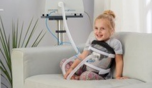 Child with NPV sitting on a couch. 