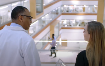 Dr. Milling walking down the stairs inside the Jacobs School. 