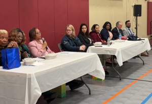 People sitting at two tables during a panel discussion. 