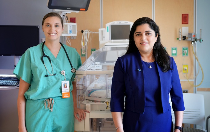 Drs. Romanov and Rawat stand in a clinical setting. 