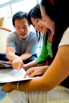 Students discussing material in a textbook. 