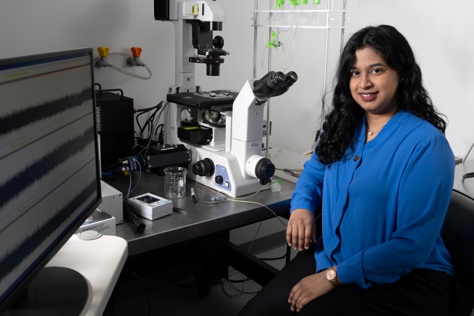 Niharika Jawalkar sitting near a microscope. 