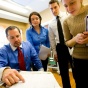 Group of four healthcare professionals reviewing paperwork. 