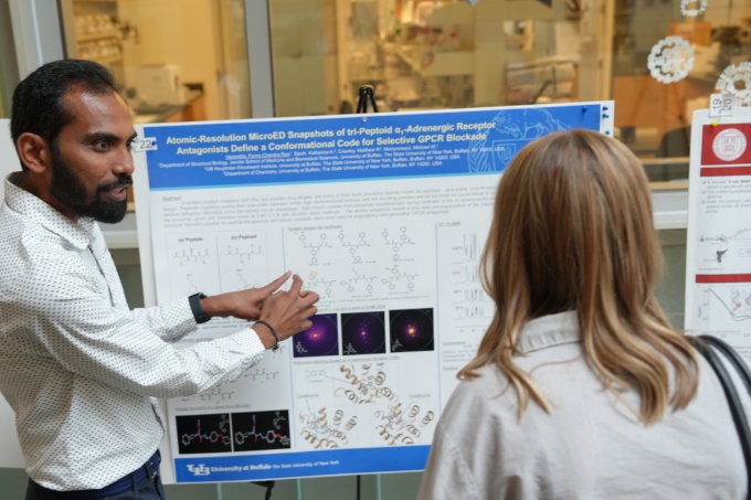 A researchers presents a poster of research findings.