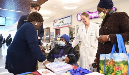 Liise Kayler (white coat), Barb Breckenridge (far left) and Jacobs School student Kelvin Anderson (next to Breckenridge) offer Judy Staten (seated) information about kidney health during a UB-ECMC World Kidney Day event March 9 at Erie County Medical Center. Staten's sister, Linda Sherman (holding shopping bag), listens in. Photo: Nancy J. Parisi. 