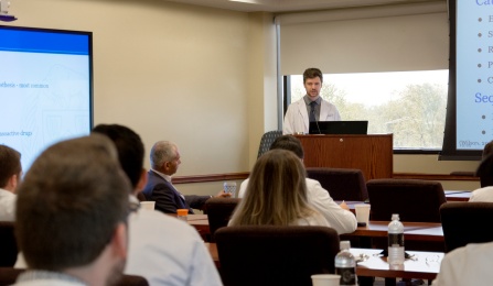A trainee speaks at a conference. 