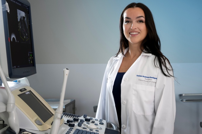 Daniela Hinchman-Dominguez, MD, standing at a computer. 
