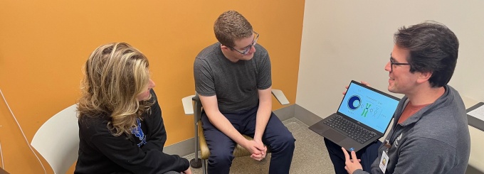 Two people meeting with a genetic counselor. 