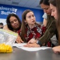 Small group looking at paper with professor. 