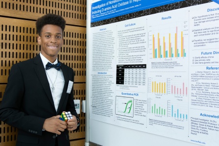 Student standing in front of research poster.