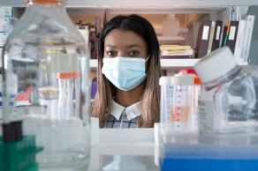 Student with a mask on in a lab.