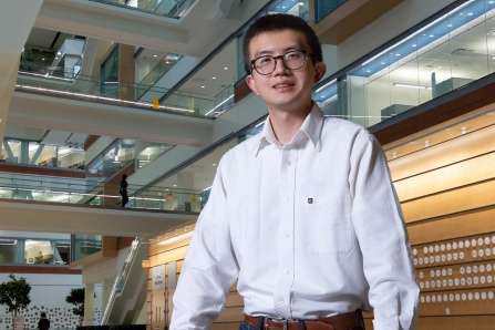 Student standing in atrium of Jacobs School building.