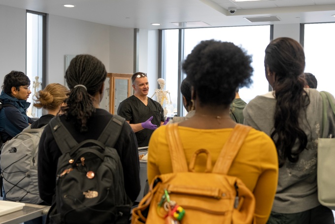 Group of high school students listening to an instructor. 