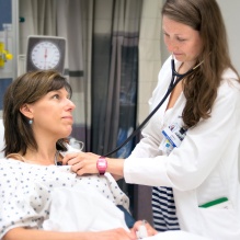 A trainee examines a patient. 