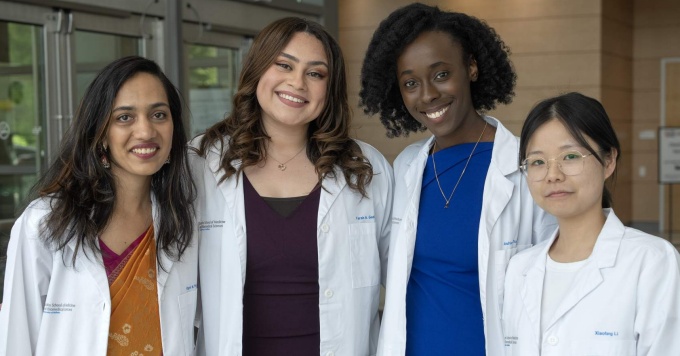 A group of four neuroscience students in white coats. 
