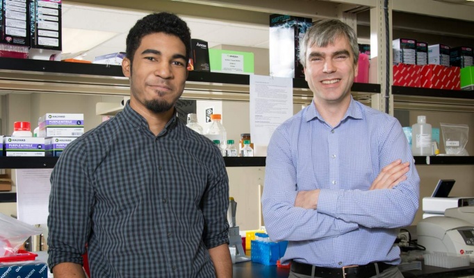 Fraser J. Sim, PhD with trainee in a lab. 