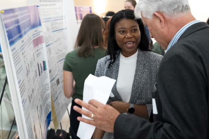 A student presenting her poster at the 2024 research day. 