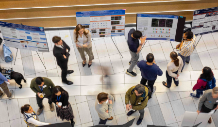 Students and faculty interacting at Neuroscience Research Day poster session. 