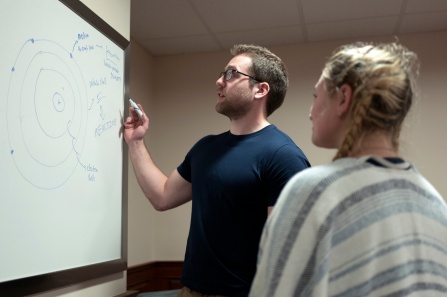 students working together at a white board. 