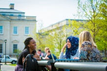 students chatting at a table on south campus. 