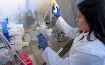 Biochemistry student at microscope. 